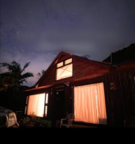 Una casa iluminada por la noche con luces encendidas en CABAÑA EN LA MONTAÑA en Macanal