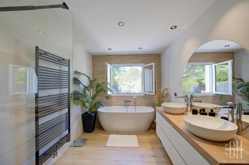 uma casa de banho com 2 lavatórios e uma grande banheira em Le Bel Air / Maison de famille em Saint-Avertin