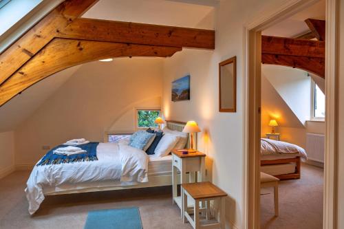 a bedroom with a king sized bed in a attic at Finest Retreats - Lower School Cottages in Minehead