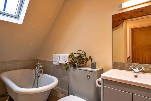 a bathroom with a toilet and a tub and a sink at Finest Retreats - Lower School Cottages in Minehead