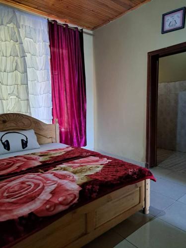 a bedroom with a bed with a red blanket on it at Green Valley in Kigali