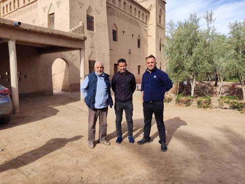 three men standing in front of a building at Dar Es Salam in Skoura