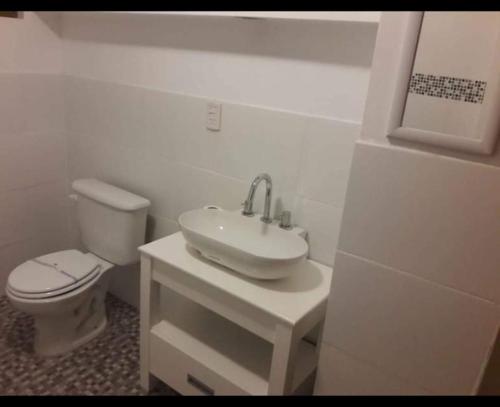a white bathroom with a toilet and a sink at SurRG in Río Grande