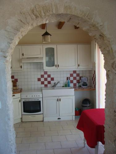 una cucina con armadi bianchi e un arco di La grange a Gasny