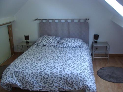 une chambre avec un lit avec une couette noire et blanche dans l'établissement La grange, à Gasny