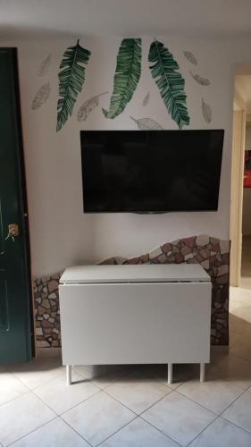 a flat screen tv on a wall with a fireplace at KOMI HOUSE in Sottomarina