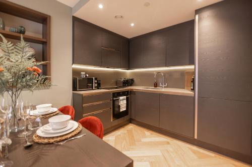 a kitchen with black cabinets and a table with red chairs at King's 23 in York