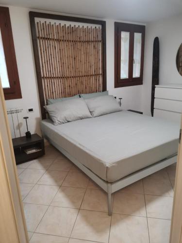 a bedroom with a large bed with white sheets at KOMI HOUSE in Sottomarina
