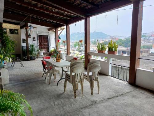 a patio with a table and chairs on a balcony at Posada Familiar Papantla in Papantla de Olarte