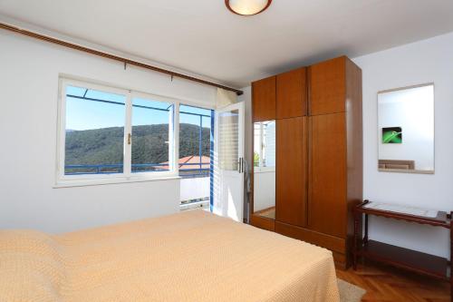 a bedroom with a bed and a window at Apartments Marija 1000 in Rabac