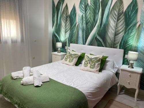a bedroom with a white bed with a green blanket at AljaLux Sevilla Bormujos in Bormujos