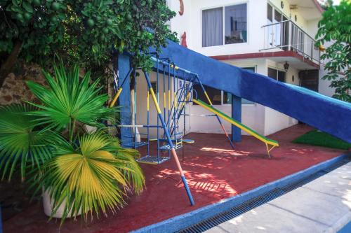 a playground with a slide in front of a building at Hotel Quinta Paraiso in Cocoyoc