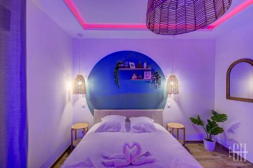 een slaapkamer met een wit bed en roze verlichting bij La Quintinha / détente et évasion in Fondettes