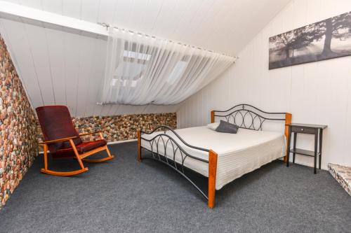 ein Schlafzimmer mit einem Bett und einem Stuhl in der Unterkunft Apartamentai Birštono centre su židiniu in Birštonas