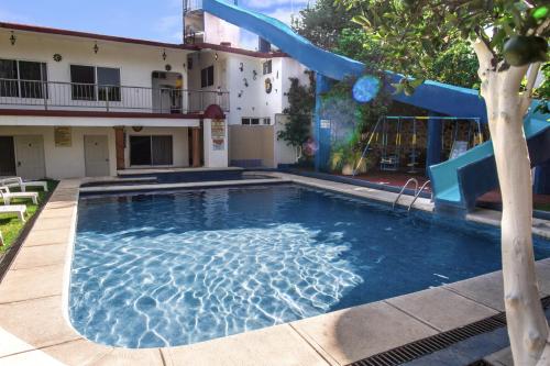 a swimming pool with a slide in front of a building at Hotel Quinta Paraiso in Cocoyoc