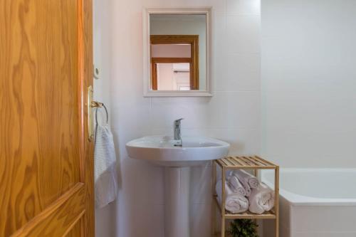 Baño blanco con lavabo y espejo en URBANIZACIÓN COPACABANA - La Manga del Mar Menor KM2 - Vistas a Mediterráneo Dormitorio doble y sofá-cama, en La Manga del Mar Menor