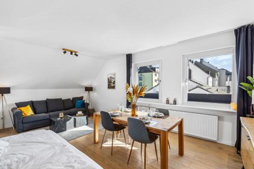 ein Wohnzimmer mit Tisch und Stühlen und einer Couch in der Unterkunft City Chalet - 73m2-Boxspringbett-neu renoviert-Küche-sehr ruhig in Bochum
