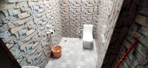 een kleine badkamer met een stenen muur bij Sakleshpur Home Stays in Sakleshpur