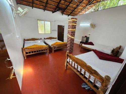 een kamer met drie bedden in een kamer bij Sakleshpur Home Stays in Sakleshpur