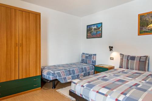 a bedroom with two beds and a cabinet at Agriturismo El Cirum Pelmo in Livinallongo del Col di Lana