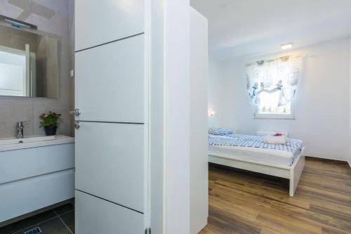 a small bedroom with a bed and a sink at Villa Miri Olive in Privlaka