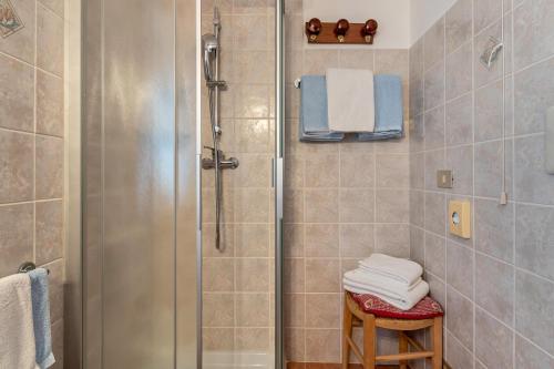 a bathroom with a shower with towels on a stool at Agriturismo El Cirum Pelmo in Livinallongo del Col di Lana