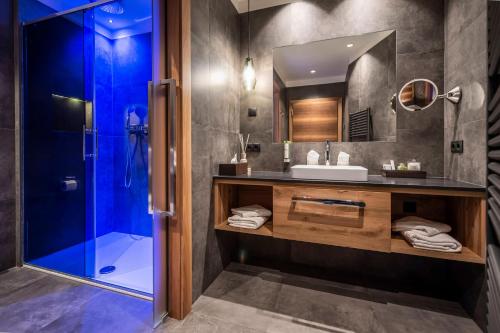 a bathroom with a sink and a shower at Hotel Chalet Das Alpenschlössel in Saltusio