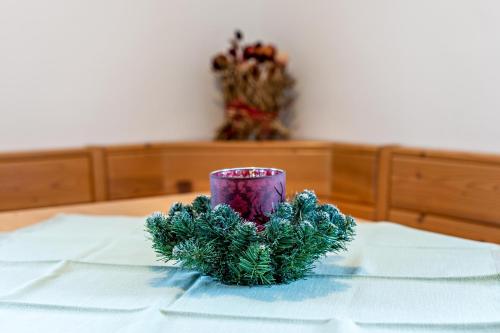 a purple cup sitting on a table with a christmasreath at Agriturismo El Cirum Pelmo in Livinallongo del Col di Lana