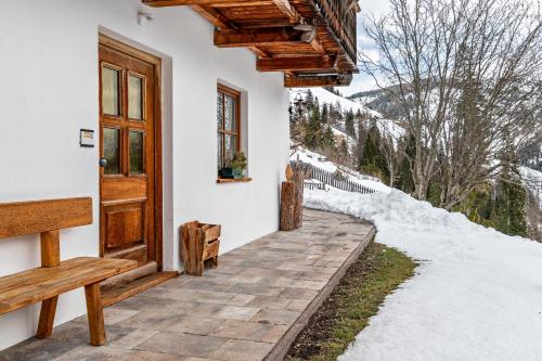 a door to a house with snow on the ground at Agriturismo El Cirum Pelmo in Livinallongo del Col di Lana