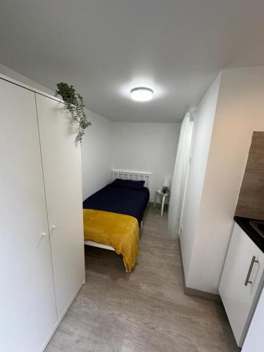 ein Schlafzimmer mit einem Bett mit einer gelben Decke in der Unterkunft Single ensuite room in London