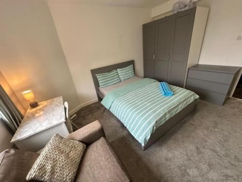 1 dormitorio pequeño con 1 cama y 1 sofá en Karen House R3, en Londres