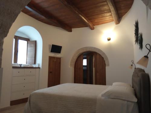 una camera con letto e porta ad arco di Tipico Resort ad Alberobello