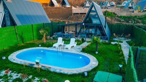 una casa y una piscina al aire libre con 2 sillas en Mouna Sapanca en Sapanca