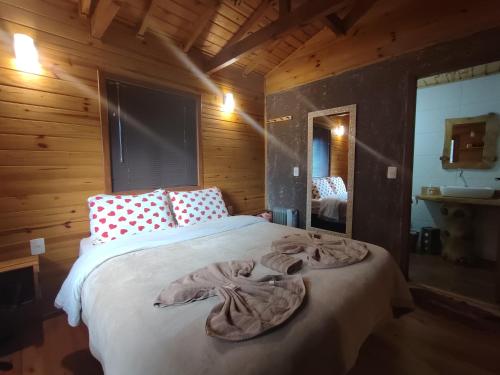 a bedroom with a bed with a blanket on it at Pousada Vale da Imbuia chalé para temporada in Urubici