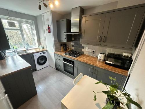 uma cozinha com um lavatório e um fogão forno superior em Karen House R2 em Londres