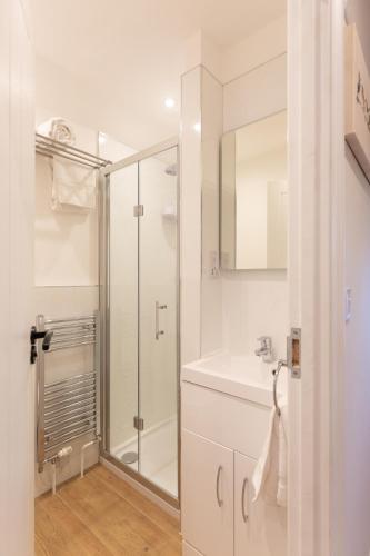 a white bathroom with a shower and a sink at The Lily Pad Suffolk in Thornham Magna