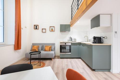 une cuisine et un salon avec un canapé dans l'établissement Roucas - Sud Passion - Calme - Fibre, à Marseille