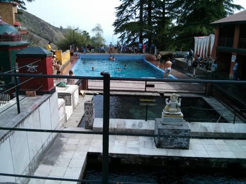 een groot zwembad met mensen in het water bij Om Tara Homestay in Dharamshala