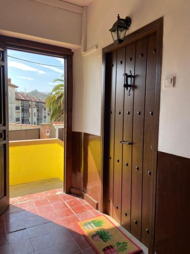 duże drewniane drzwi w pokoju z oknem w obiekcie PLENO CENTRO COMILLLAS-3 Hab, 2 Baños w mieście Comillas