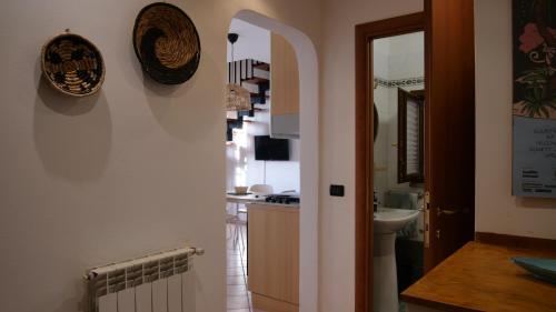 a kitchen with a sink and a mirror and a hallway at La Casina di Chloe in Livorno