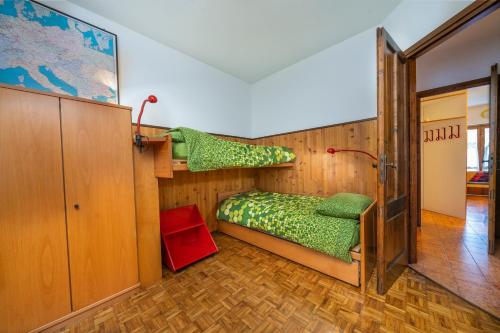 een kamer met een bed en een stapelbed bij Zoncolan Mountain Lodge in Ravascletto