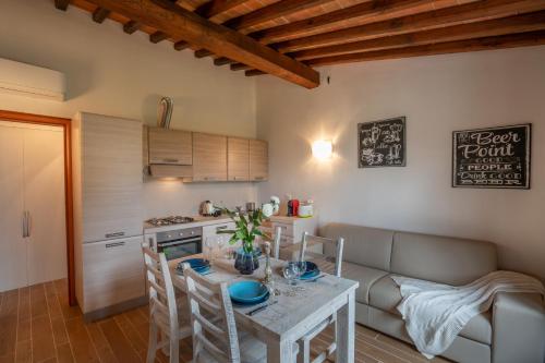 a kitchen and living room with a table and a couch at Casa d'Orcia in Pienza