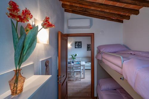 a bedroom with a bunk bed and a vase with flowers at Casa d'Orcia in Pienza
