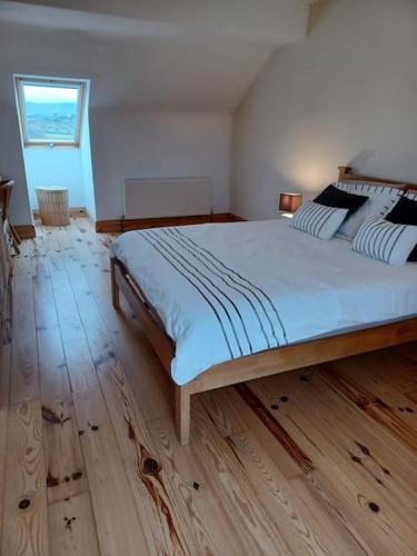 1 dormitorio con 1 cama grande y suelo de madera en Marina View - Cahersiveen, en Cahersiveen