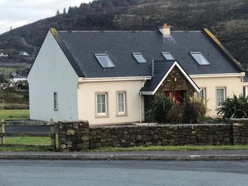 ein weißes Haus mit einer Steinmauer in der Unterkunft Marina View - Cahersiveen in Cahersiveen
