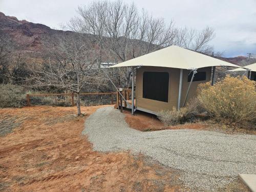 a tent in a field with a mountain in the background at HTR Moab in Moab