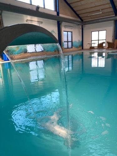 a swimming pool with a water fountain in it at Himmerland camping & Feriecenter in Års