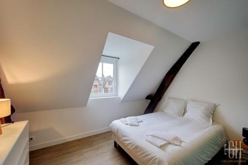 a bedroom with a bed with white sheets and a window at Le Connemara / Plumereau in Tours