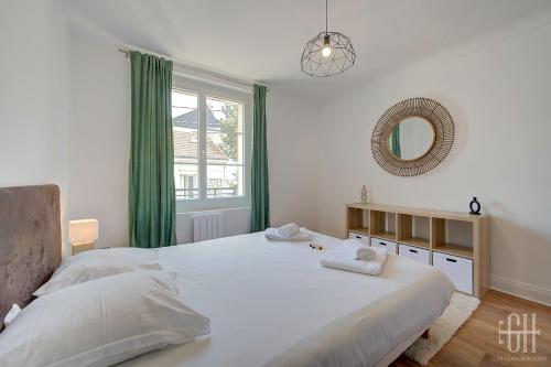 une chambre avec un grand lit blanc et un miroir dans l'établissement L'oiseau blanc / central - piscine du lac, à Tours