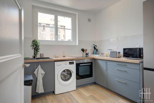 une cuisine avec un lave-linge et un sèche-linge sur un comptoir dans l'établissement L'oiseau blanc / central - piscine du lac, à Tours